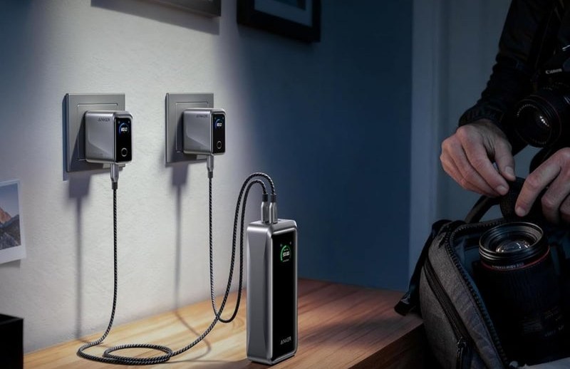 Power bank charging on a desk beside camera gear